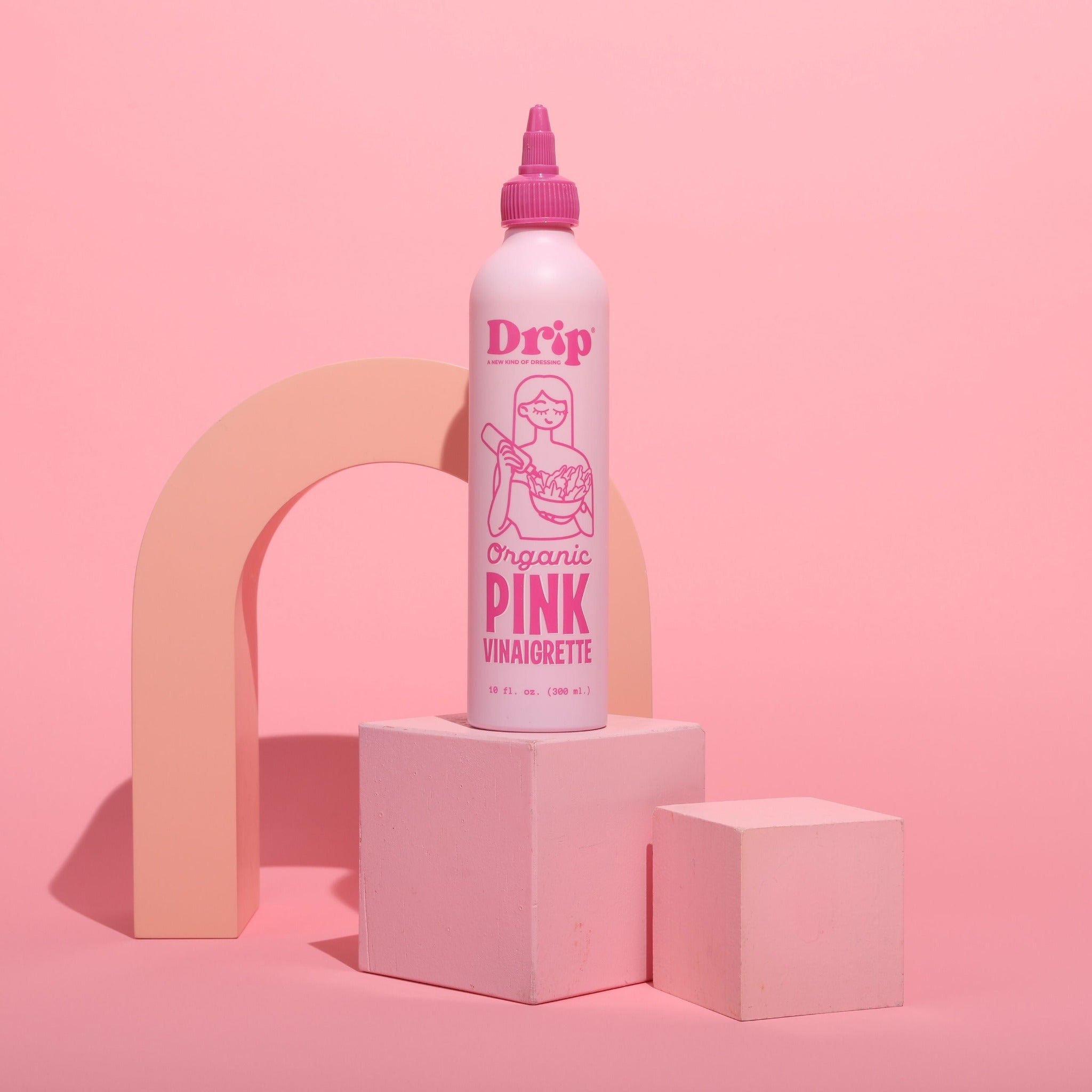 Drip Organic Pink Vinaigrette bottle on a blush pink set